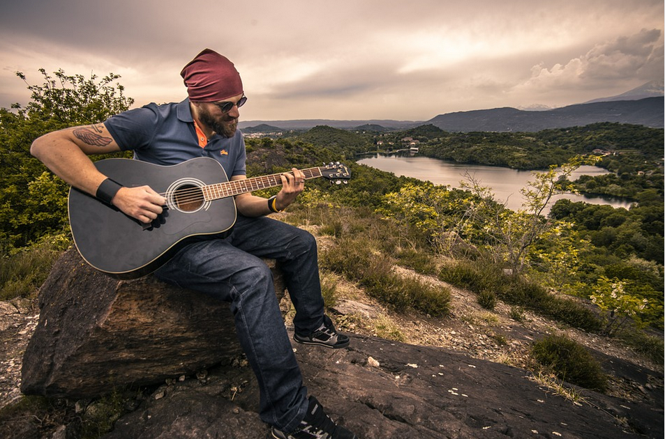 a man outdoors with a guitar